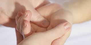 Hand reflexology being performed on a client's hand